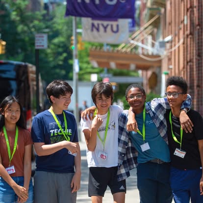 Five teens standing together on a street