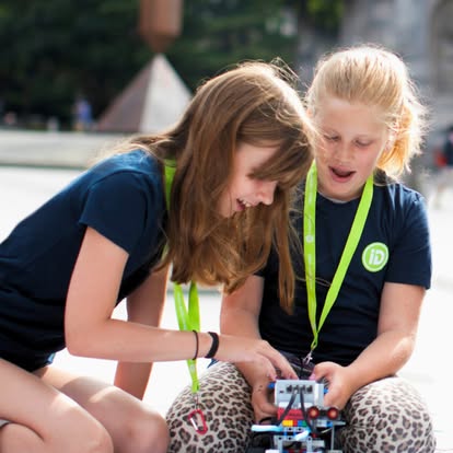 Two children working on a small robot
