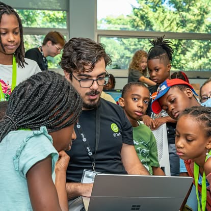 Adult and children looking at a laptop screen