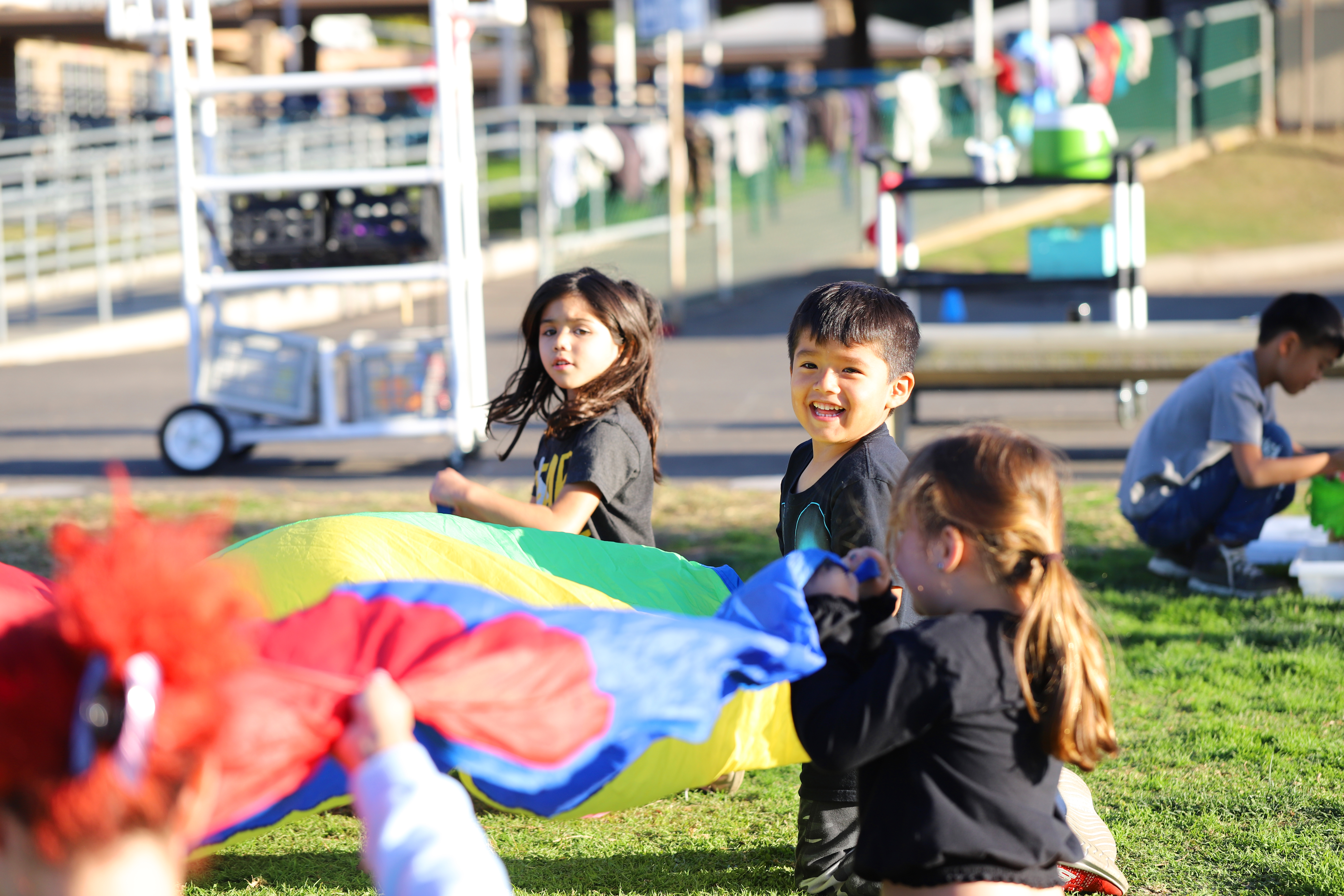 Children playing with a colorful parachute outdoors