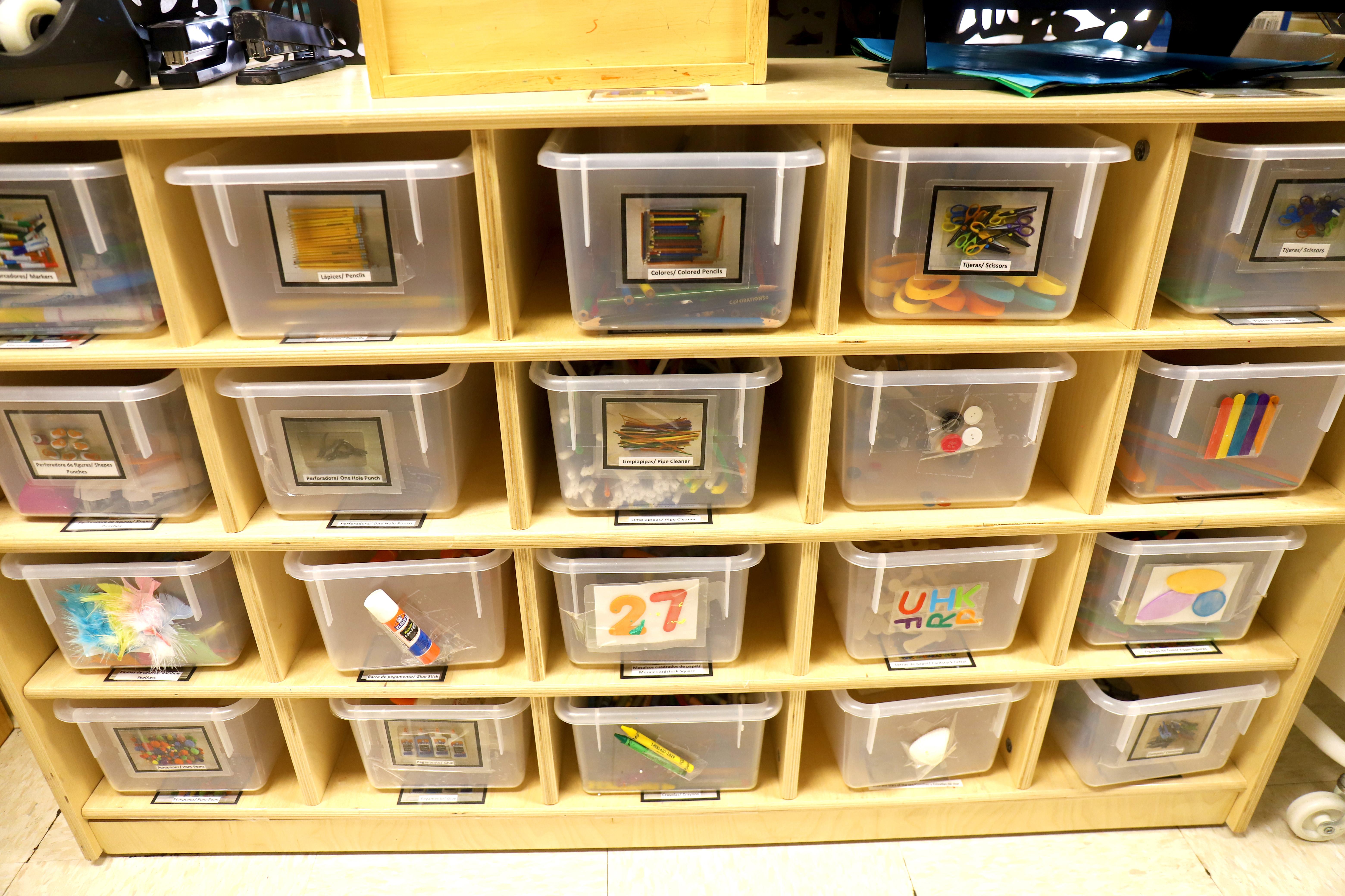 Shelving unit with clear plastic bins containing various items