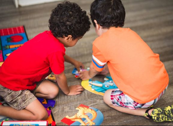 Two children playing with toys on the floor