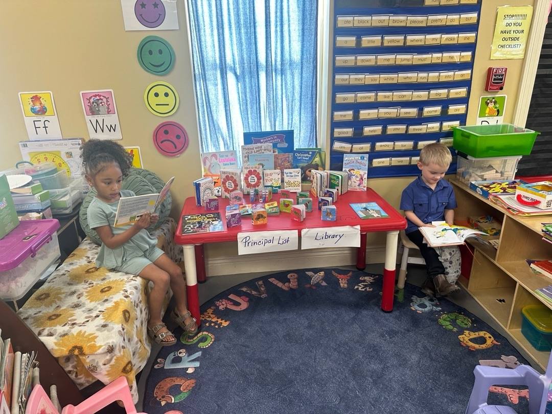 Two children reading books in a colorful classroom