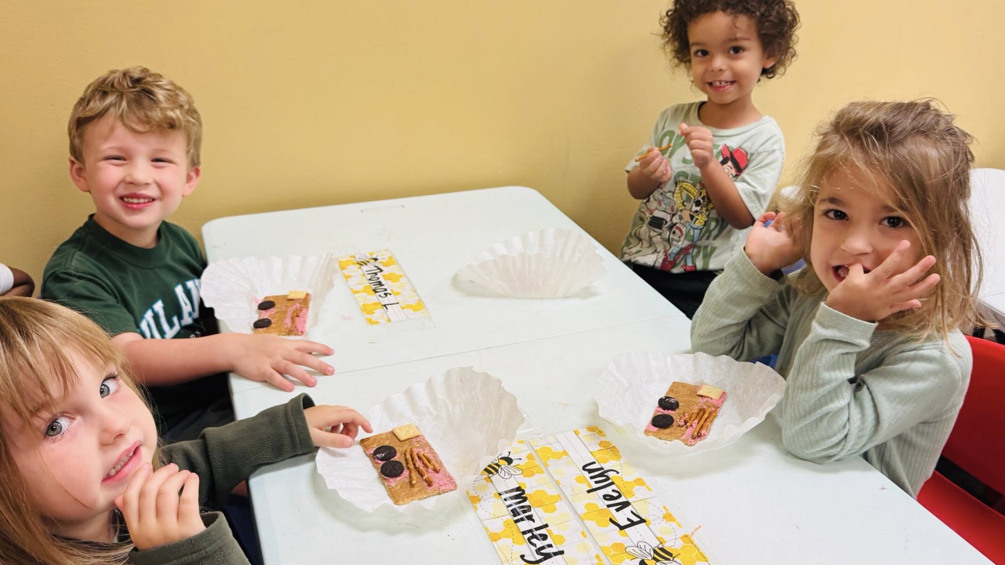 Four children at a table with graham cracker treats