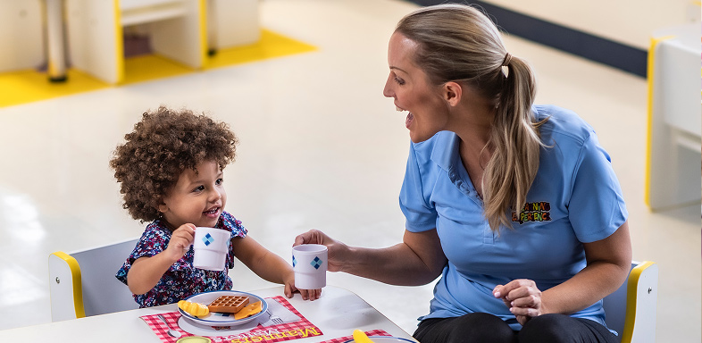 A woman and a child at a table with plates and cups