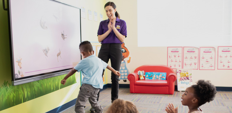 Teacher and children interacting with an interactive whiteboard in a classroom