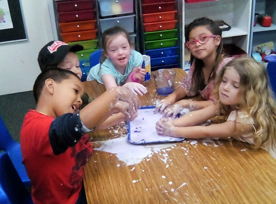 Children playing with messy craft materials at a table