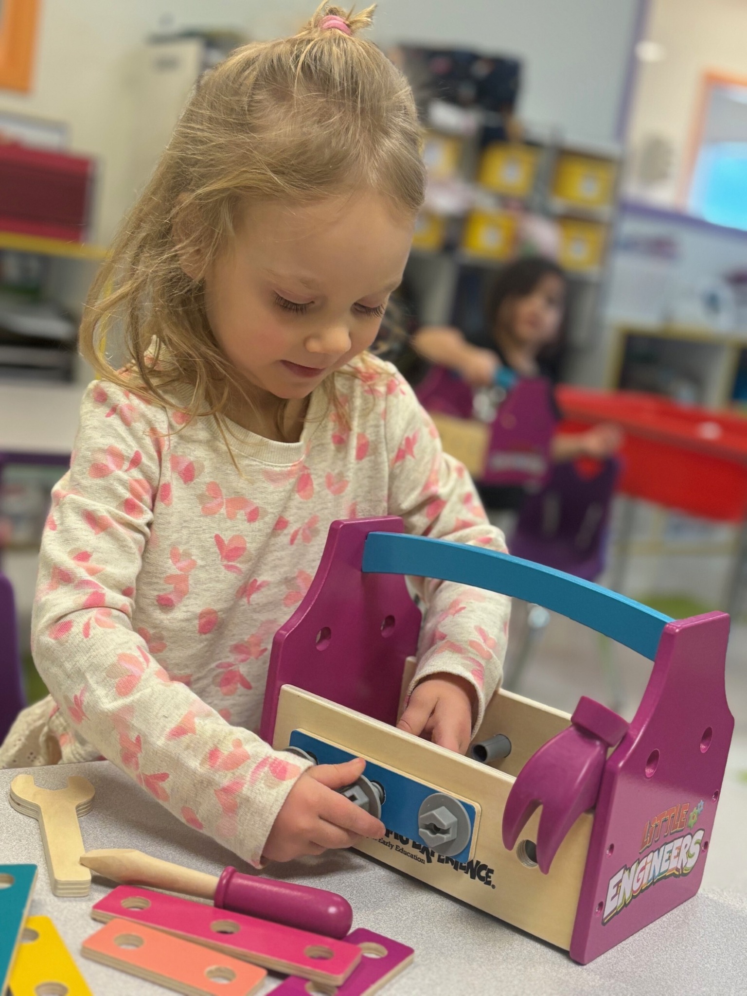 Child playing with a toy toolbox and tools