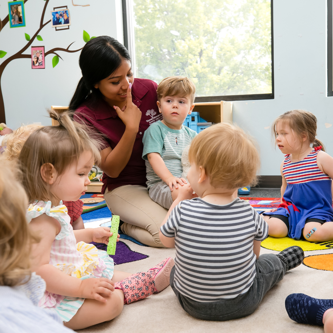 Adult and children sitting on floor in a classroom