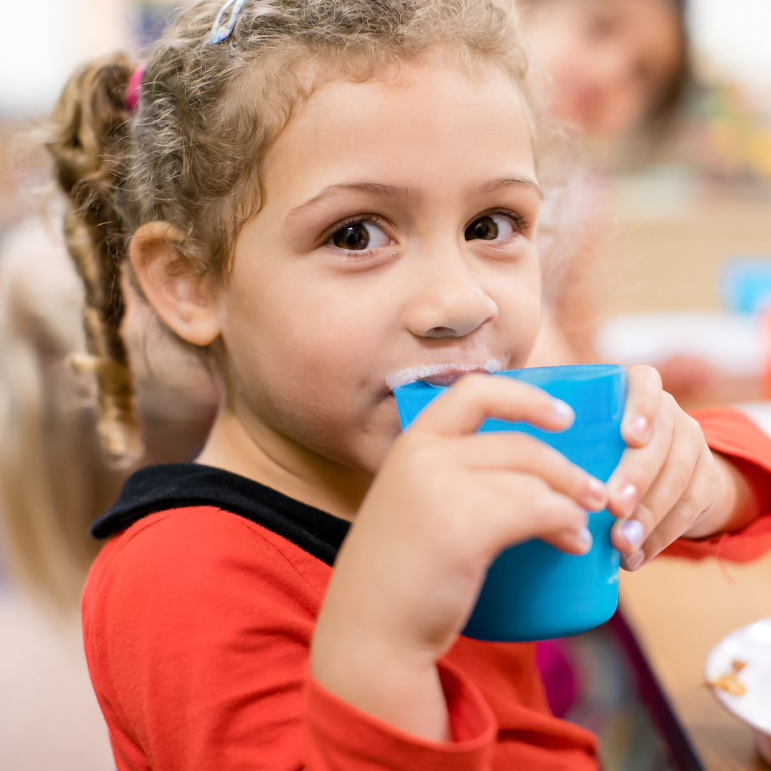 Child drinking from a blue cup