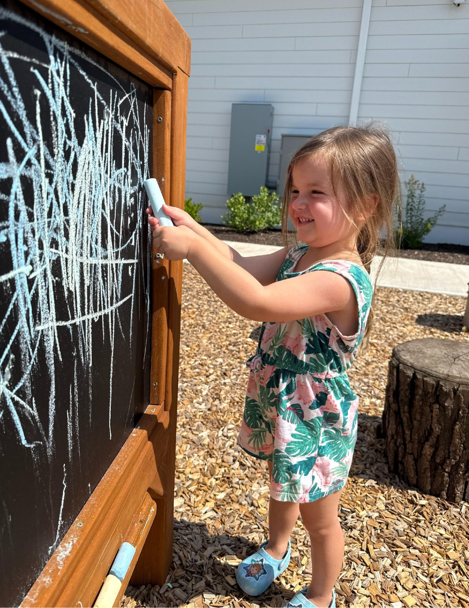 Child drawing on a chalkboard with chalk