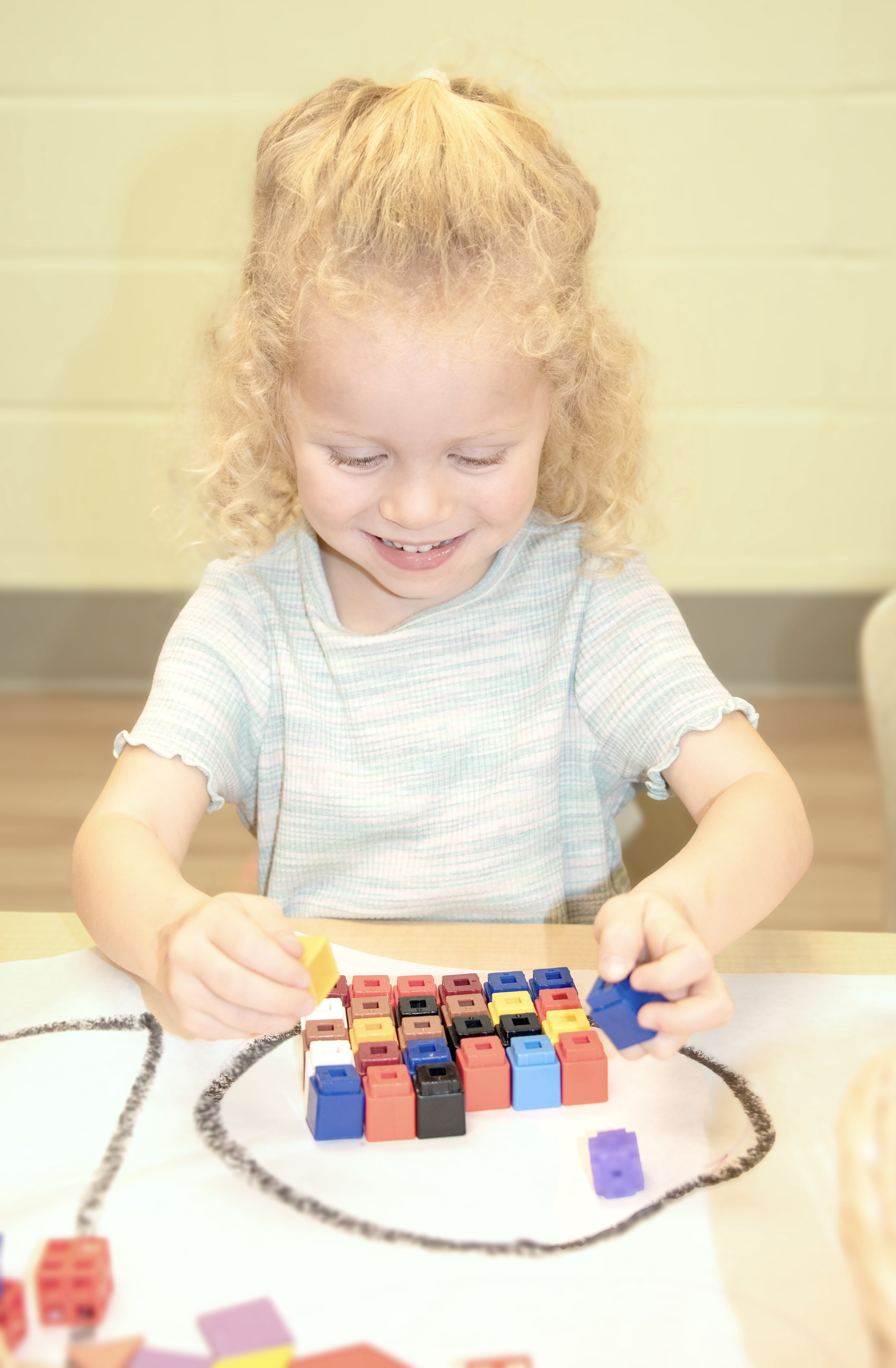 Child playing with colorful building blocks on a table