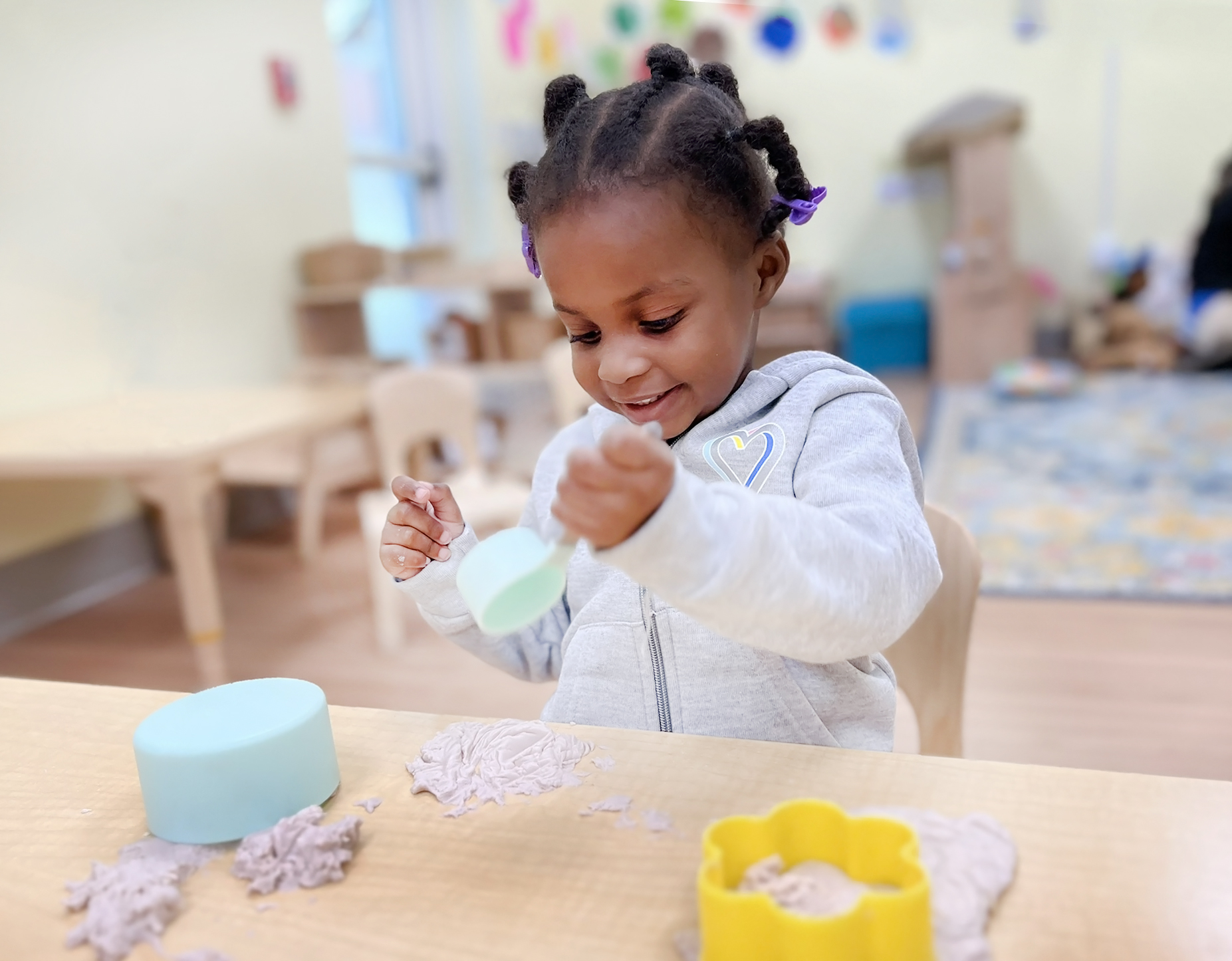 Child playing with kinetic sand at a table