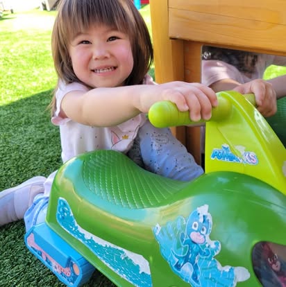 Child on a green ride-on toy