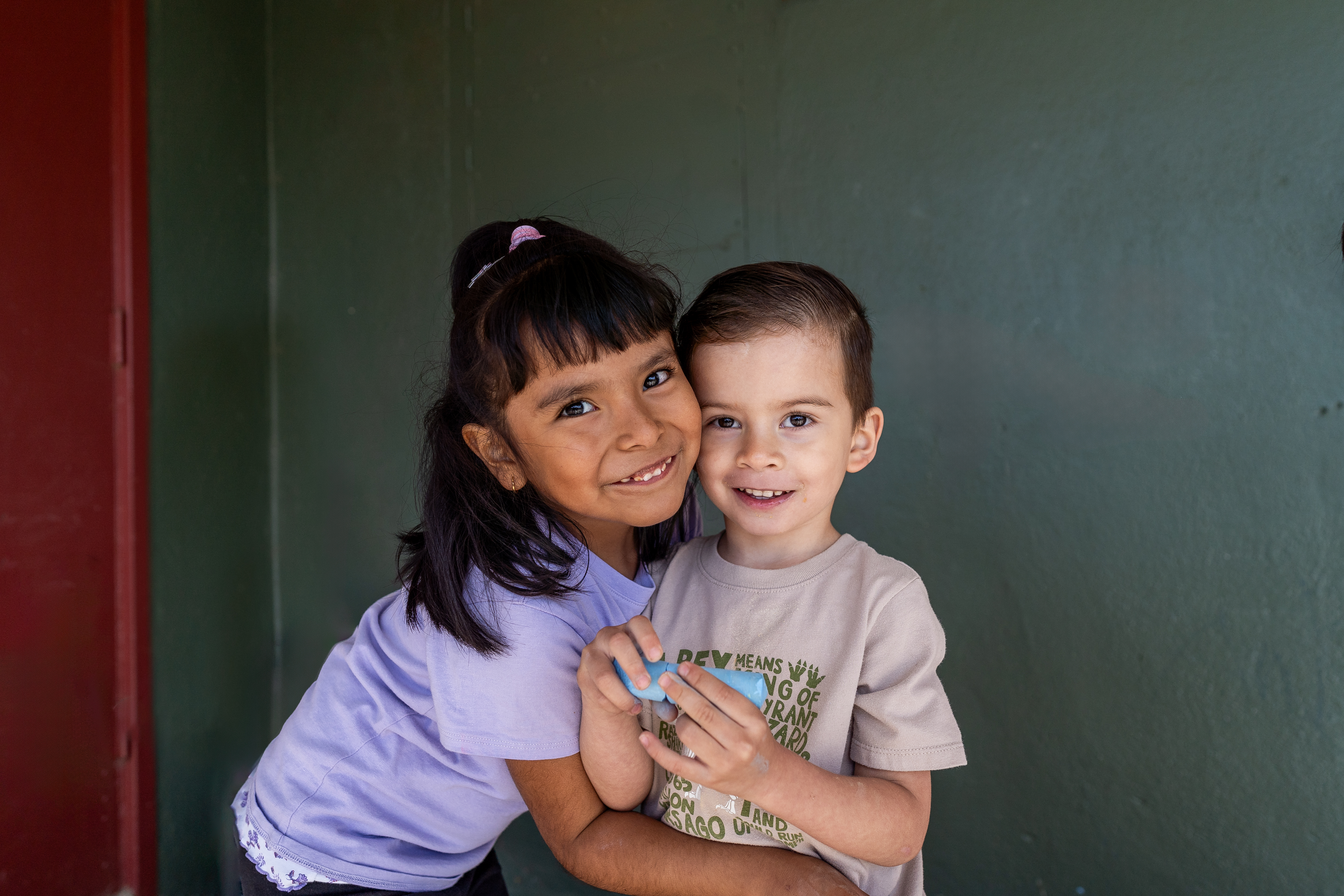 Two children smiling and embracing