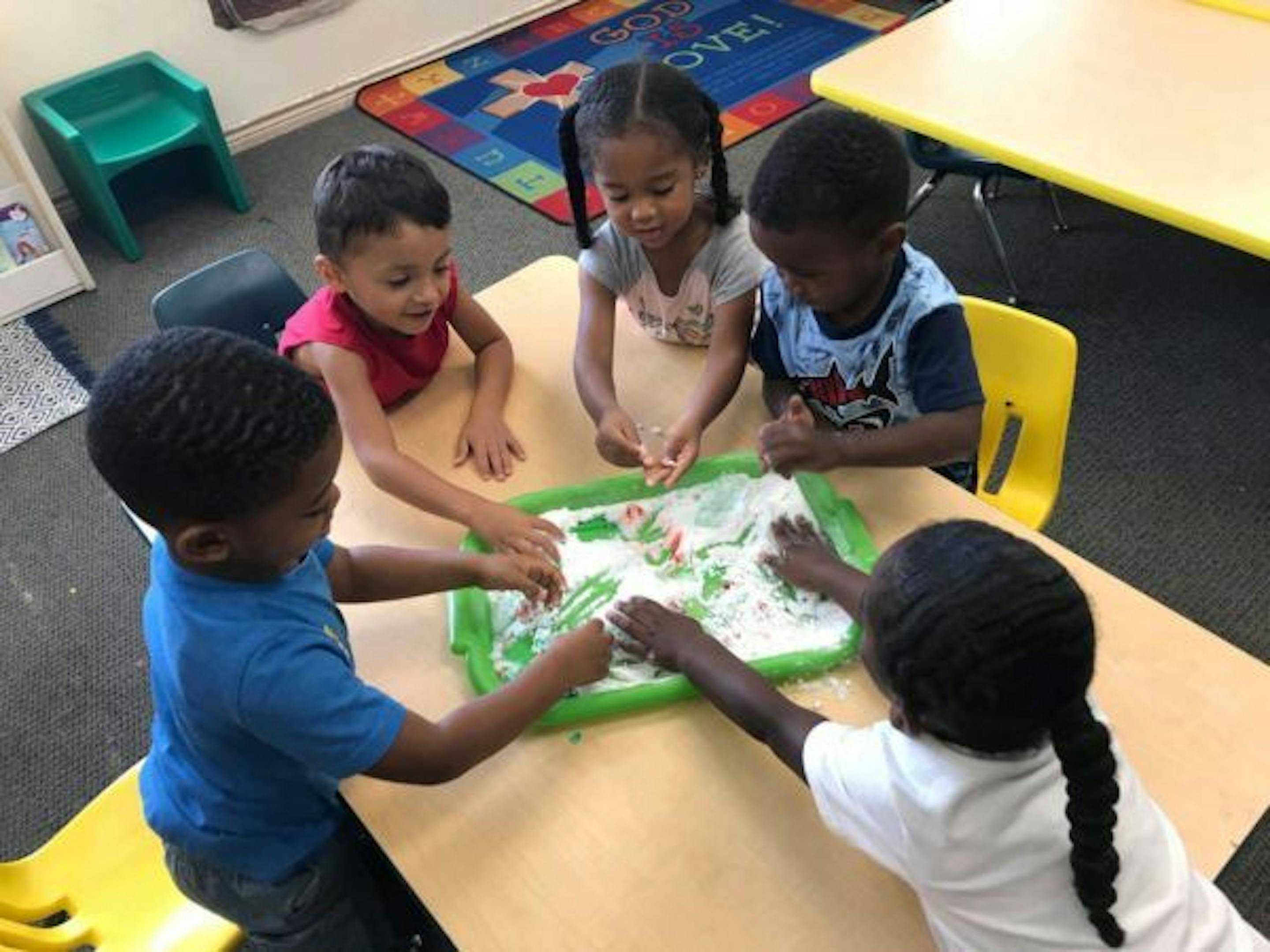 Children playing with sensory bin at a table
