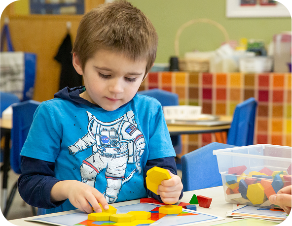 Child playing with colorful geometric shapes at a table