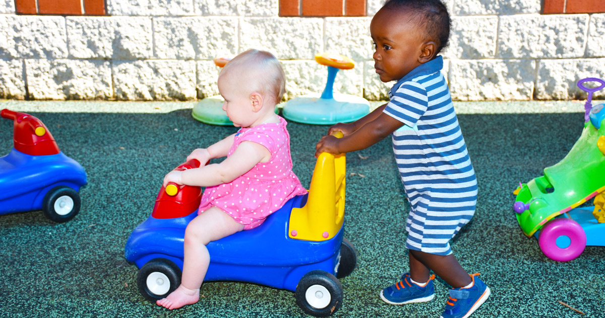 Two children playing with ride-on toys