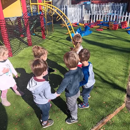Children holding hands in a circle on a playground