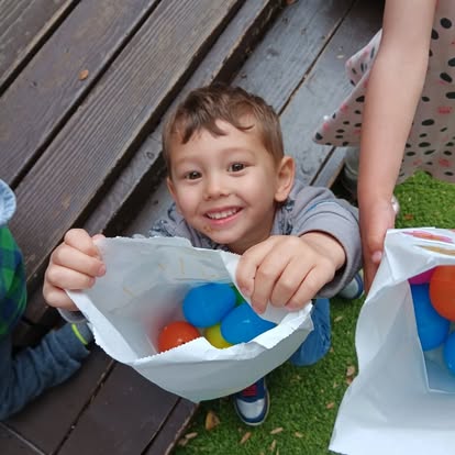 Child holding a bag of colorful plastic eggs