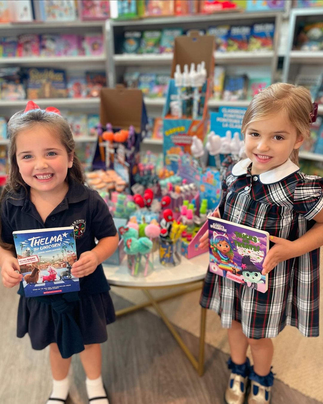Two children holding books in a store