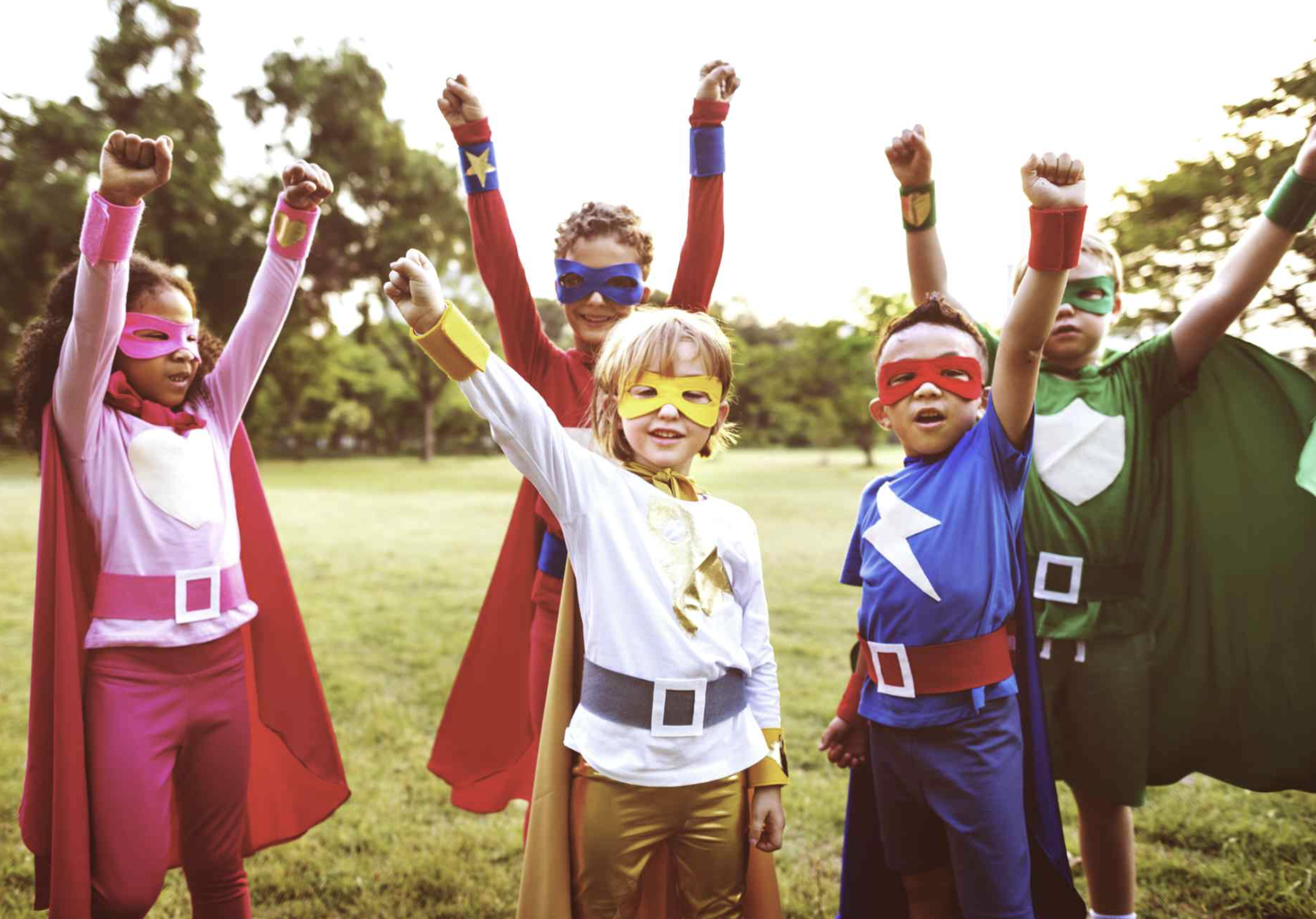 Children in superhero costumes with arms raised