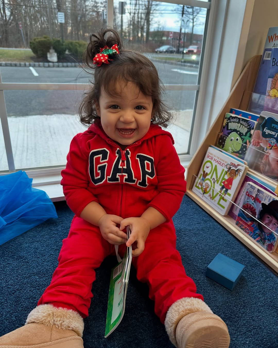 Child in red GAP outfit holding a book