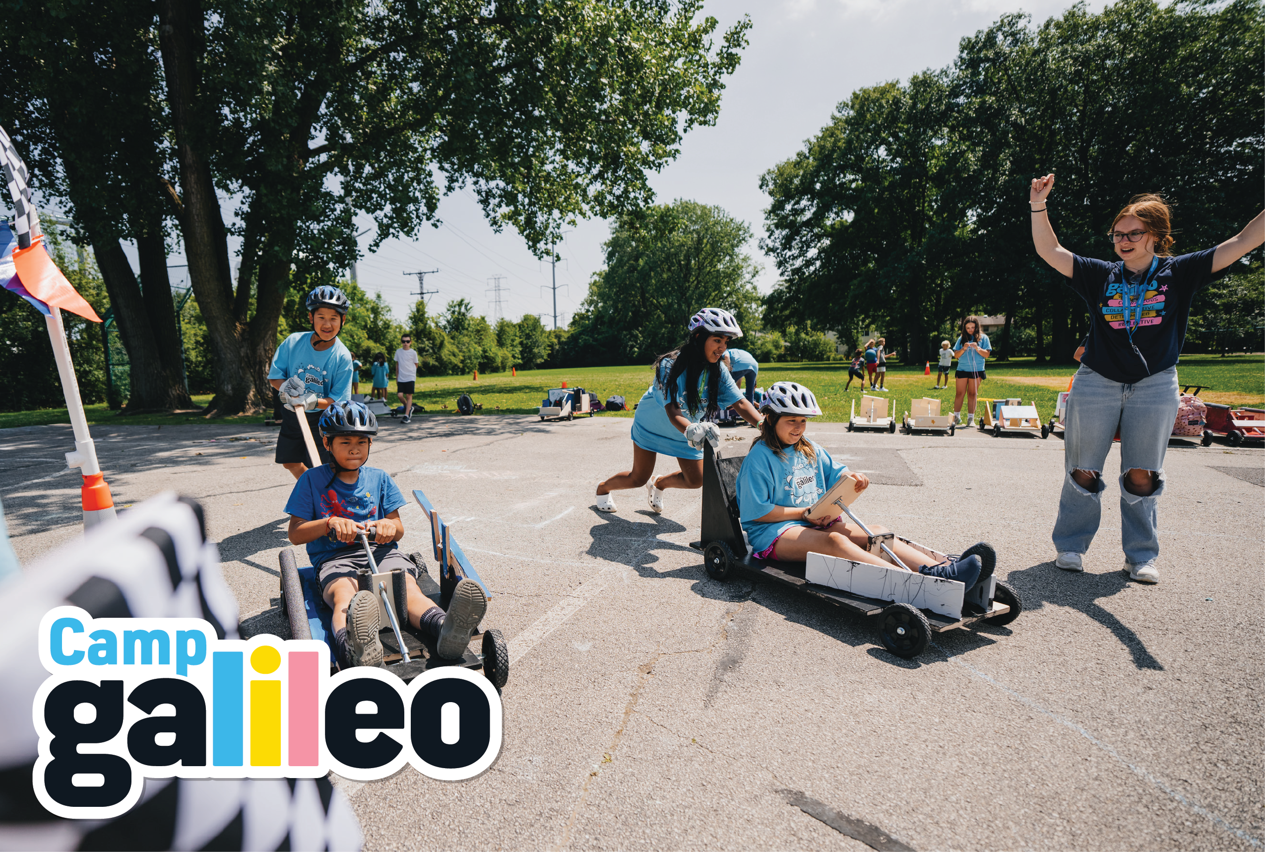 People in helmets racing in small carts outdoors