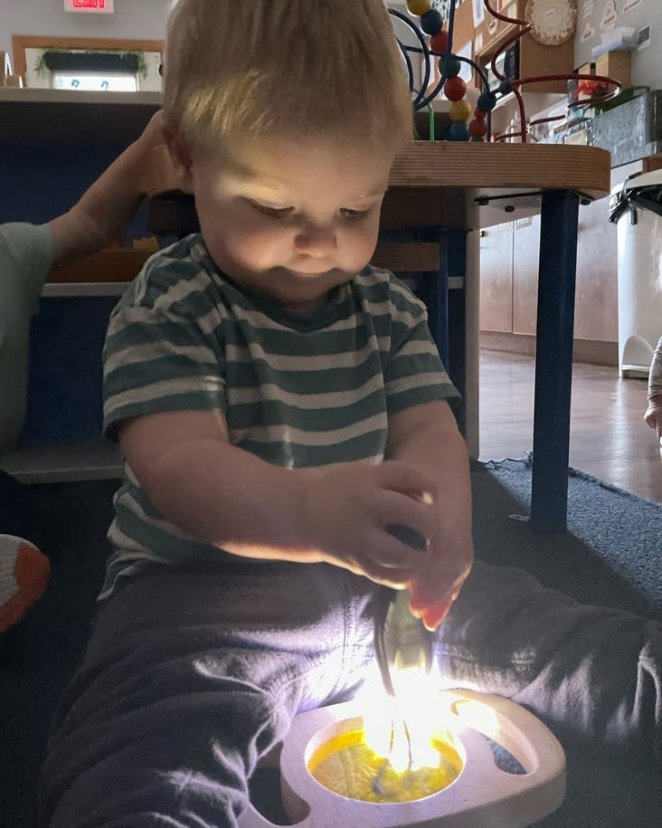 Child playing with a light-up toy in a room