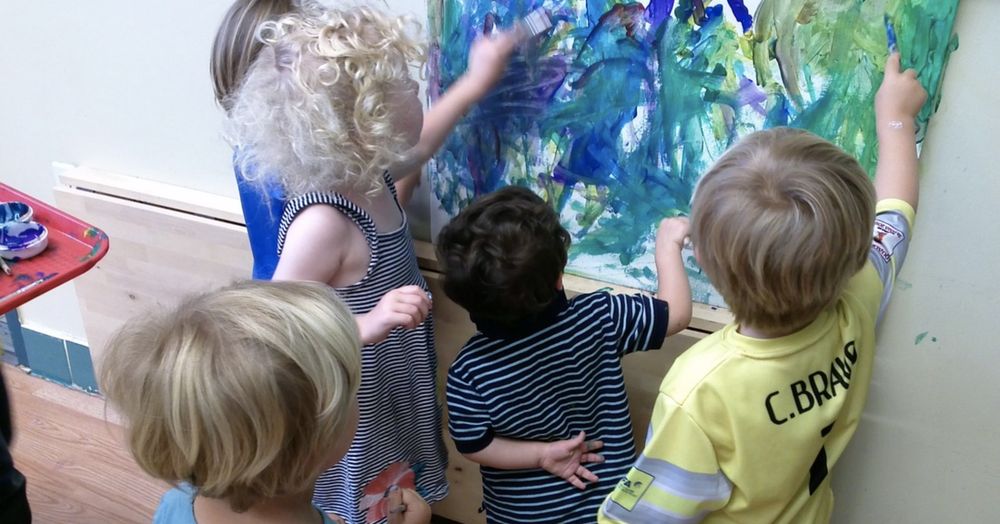 Children painting on a large canvas