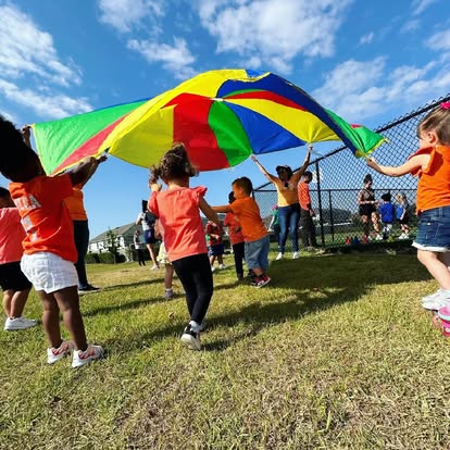 Children playing with a large colorful parachute outdoors