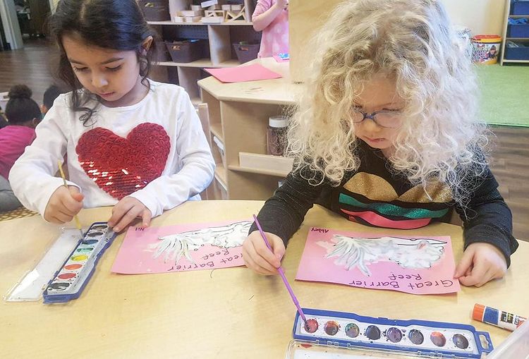Two children painting at a table