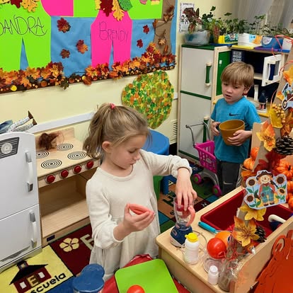 Child playing with toy blender, another child holding a bowl