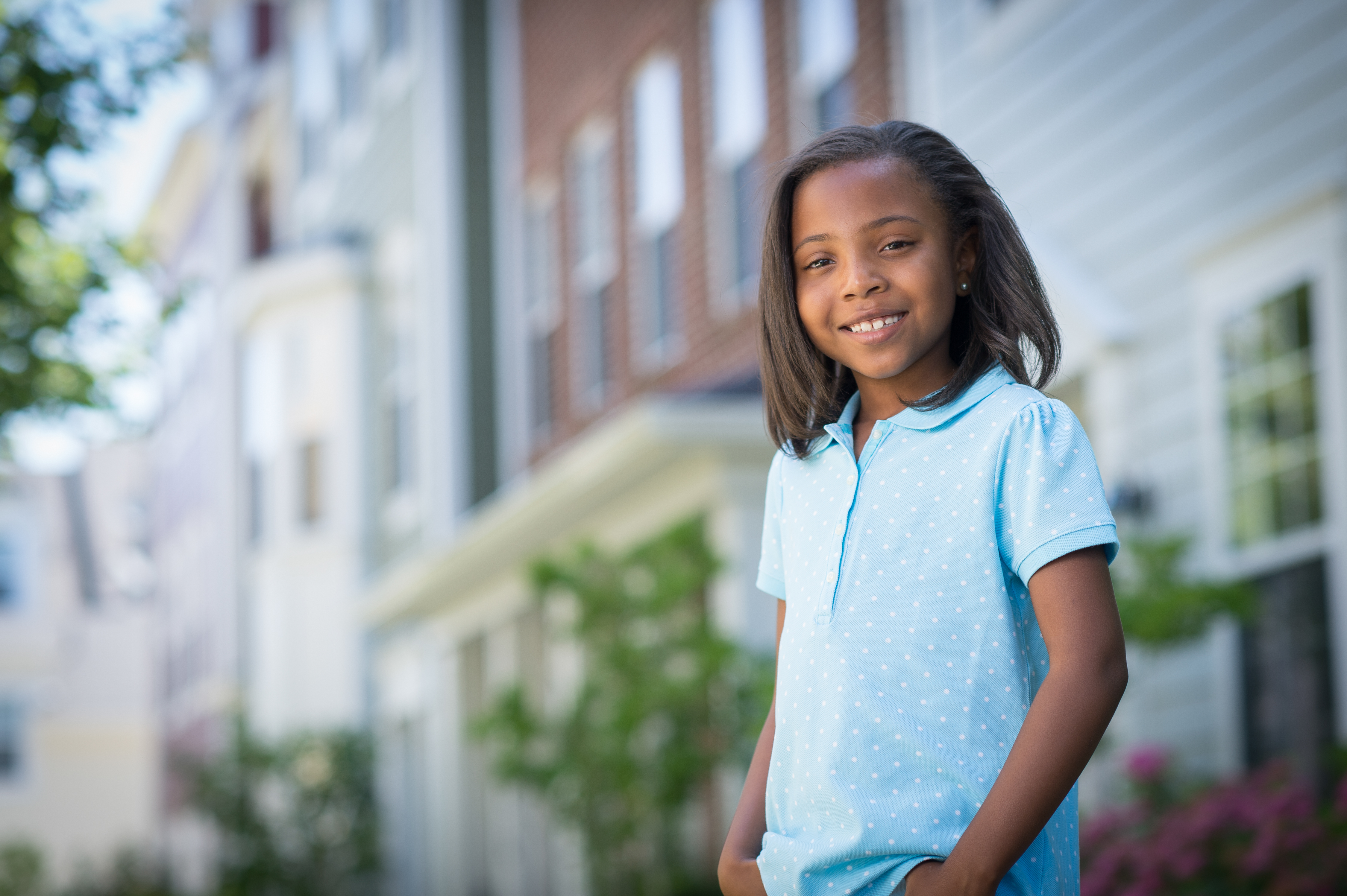 Child in a blue polka dot shirt smiling