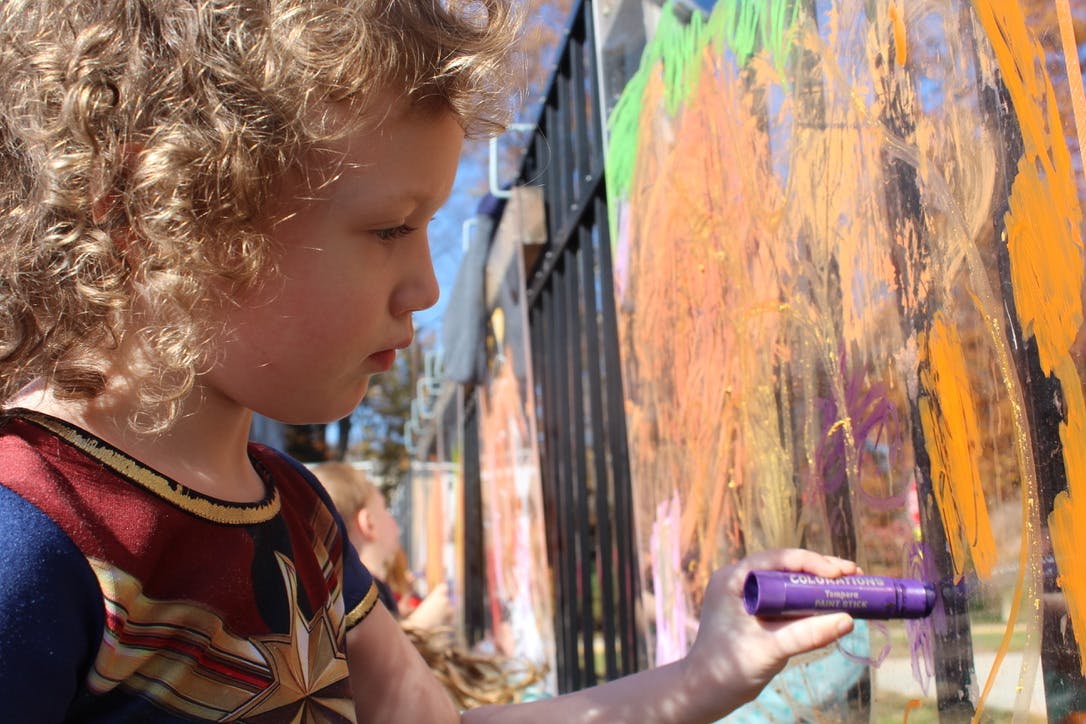 Child drawing on a surface with a purple marker