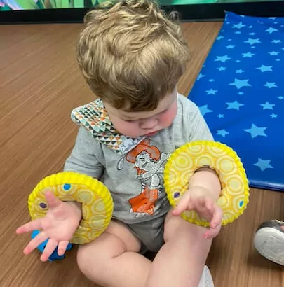 Child playing with yellow ring toys