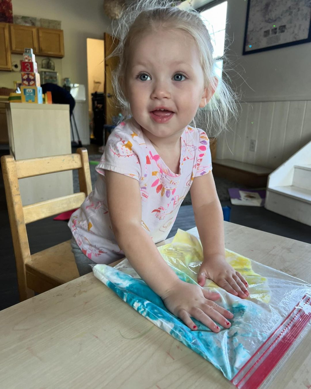 Child playing with a colorful sensory bag on a table