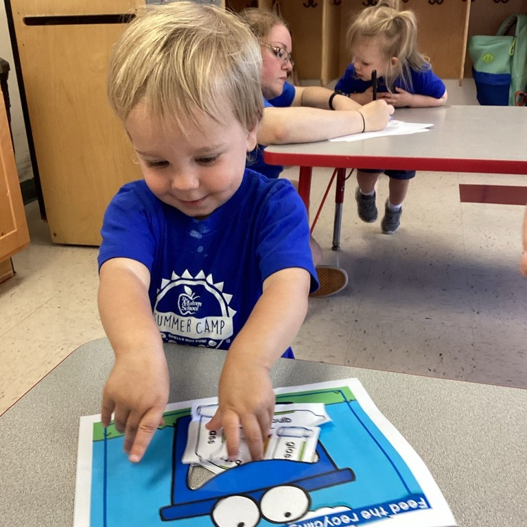 Child playing with a paper craft on a table