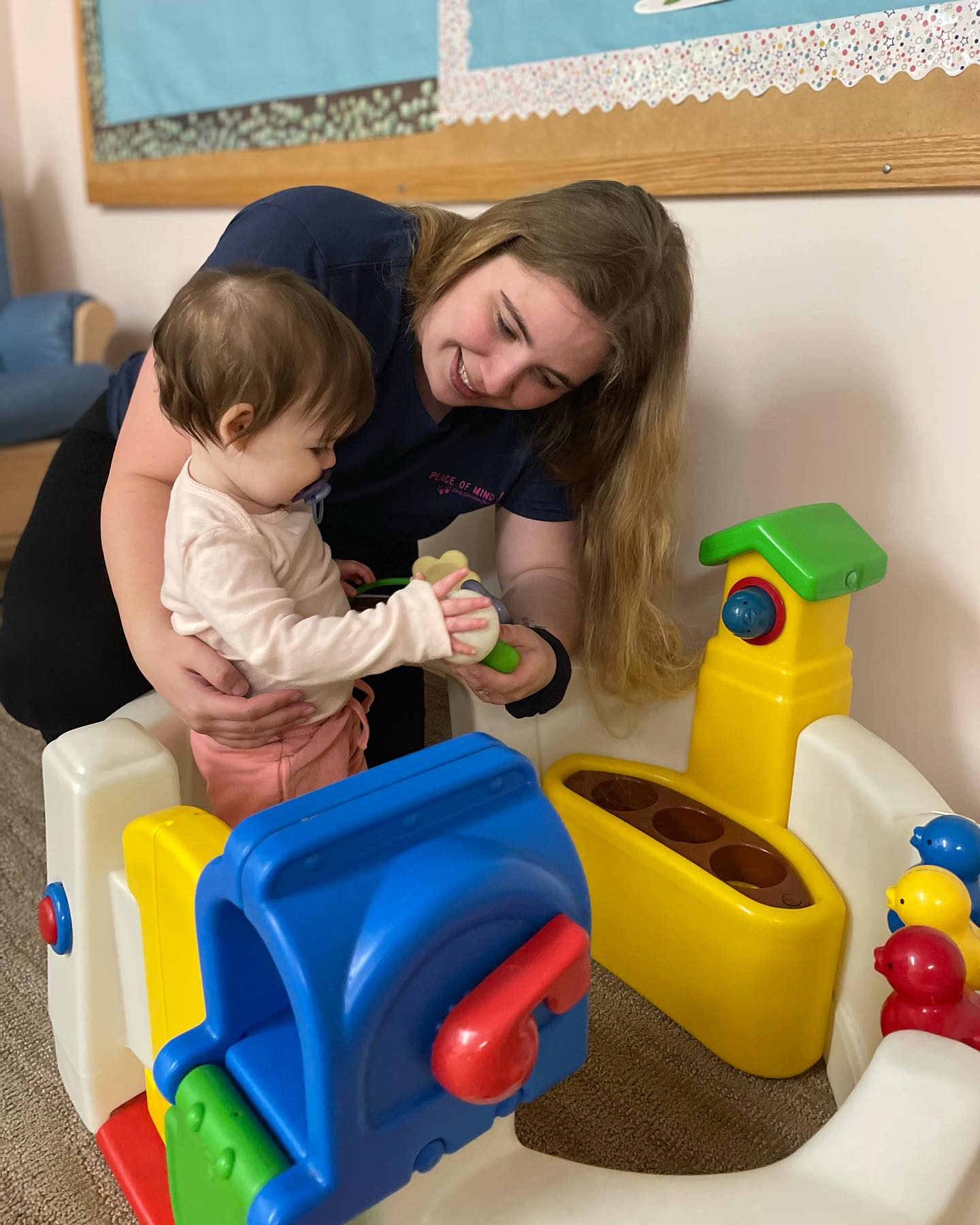 Person and child playing with colorful toys