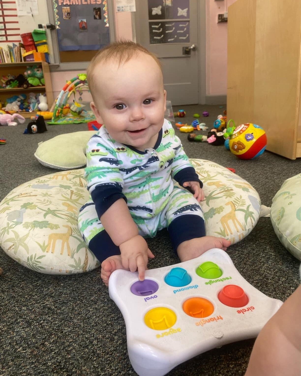 Child sitting on floor playing with a colorful toy
