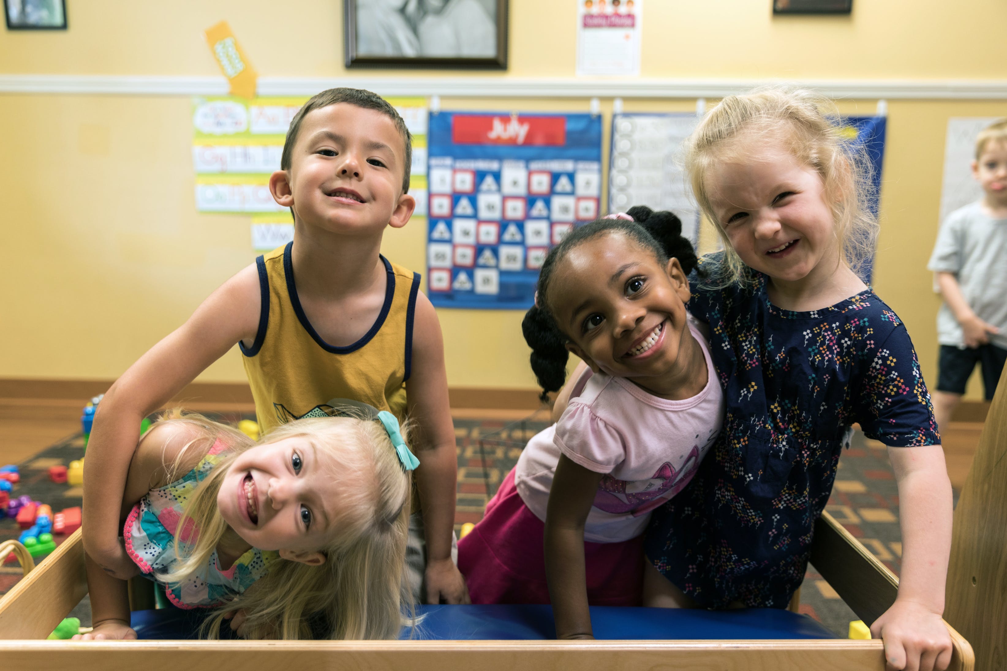 Four children playing in a classroom