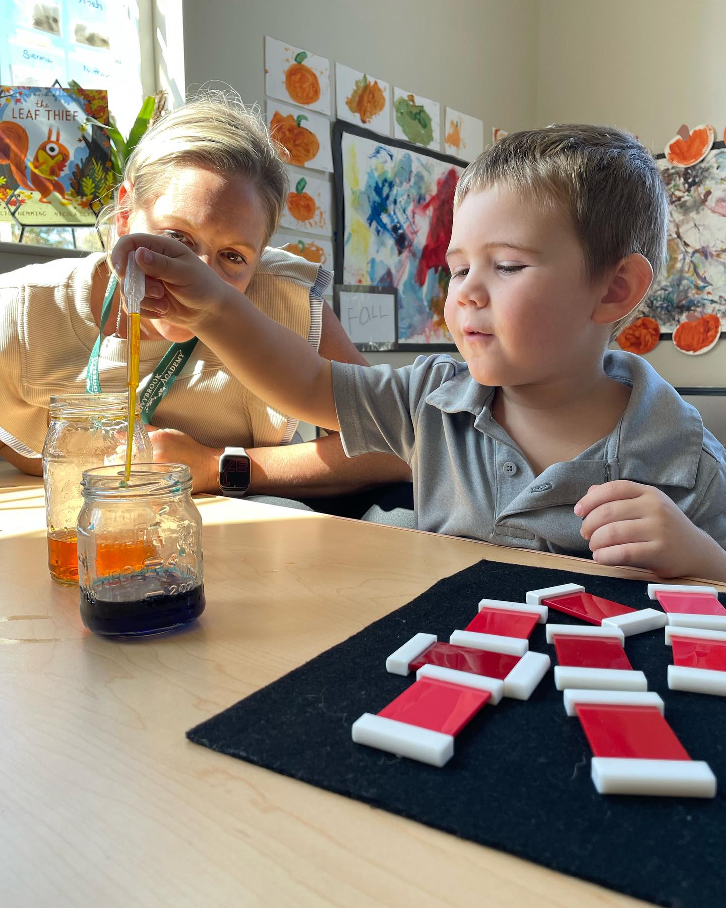 Adult and child using droppers with liquid in jars