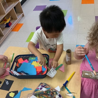 Children working on craft projects at a classroom table