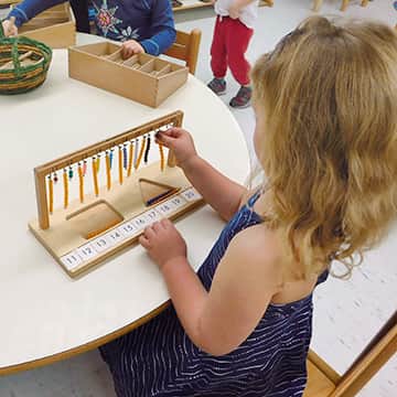 Child playing with a counting toy at a table