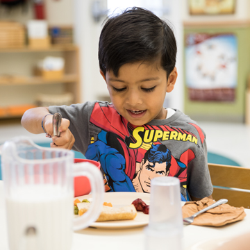 Child eating a meal at a table
