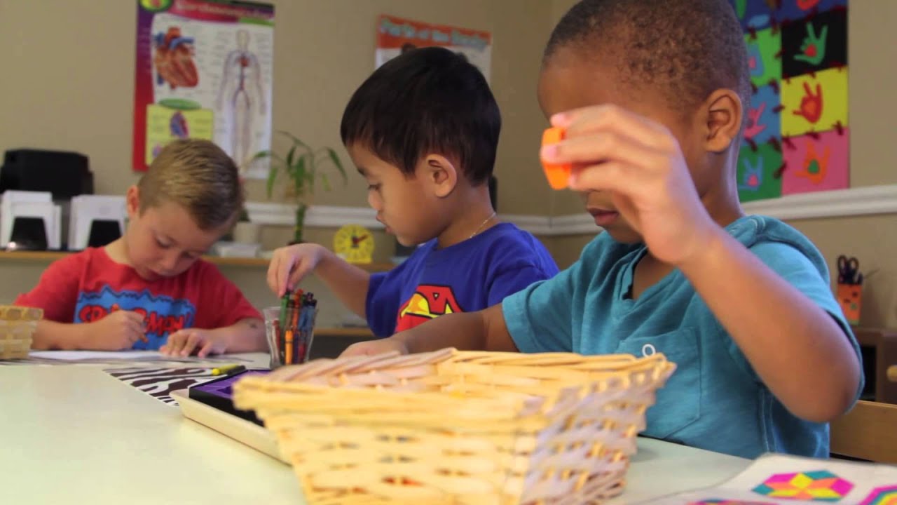 Three children at a table engaged in an activity