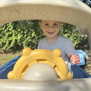 Child playing in a toy car