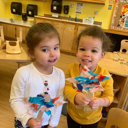 Two children holding crafts in-progress craft projects