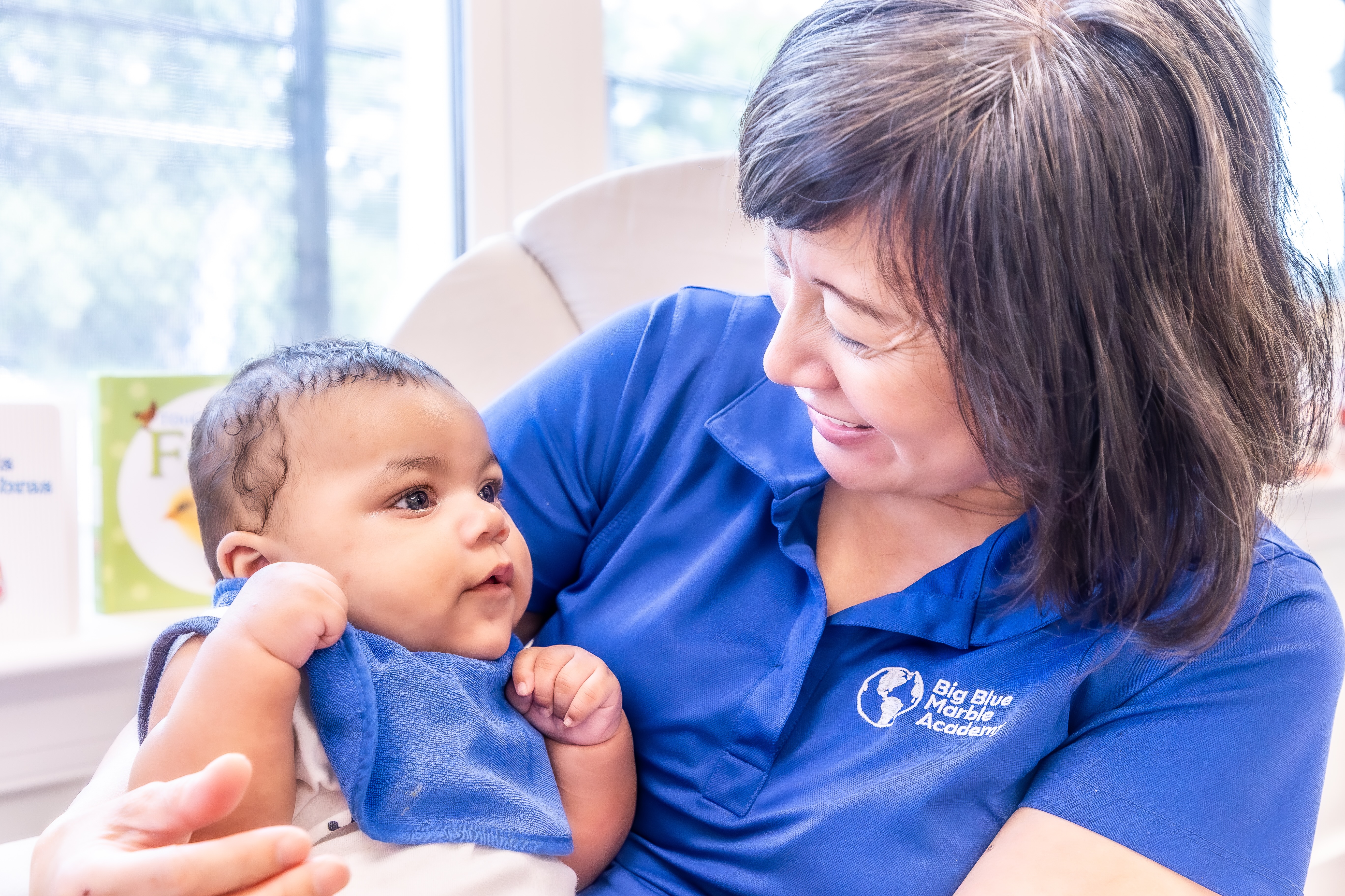 Adult holding a baby in a daycare setting