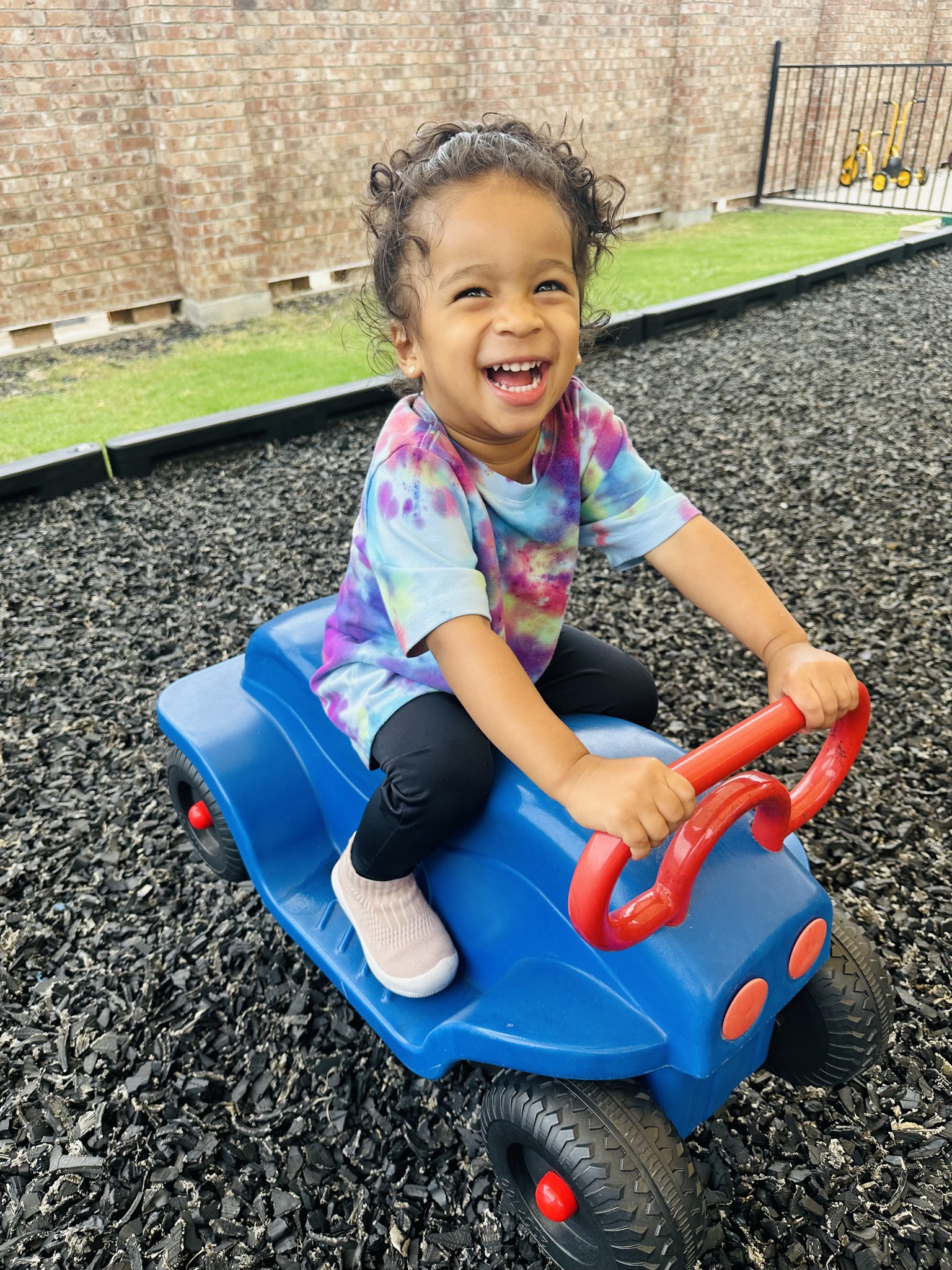 Child on a blue ride-on toy on a playground